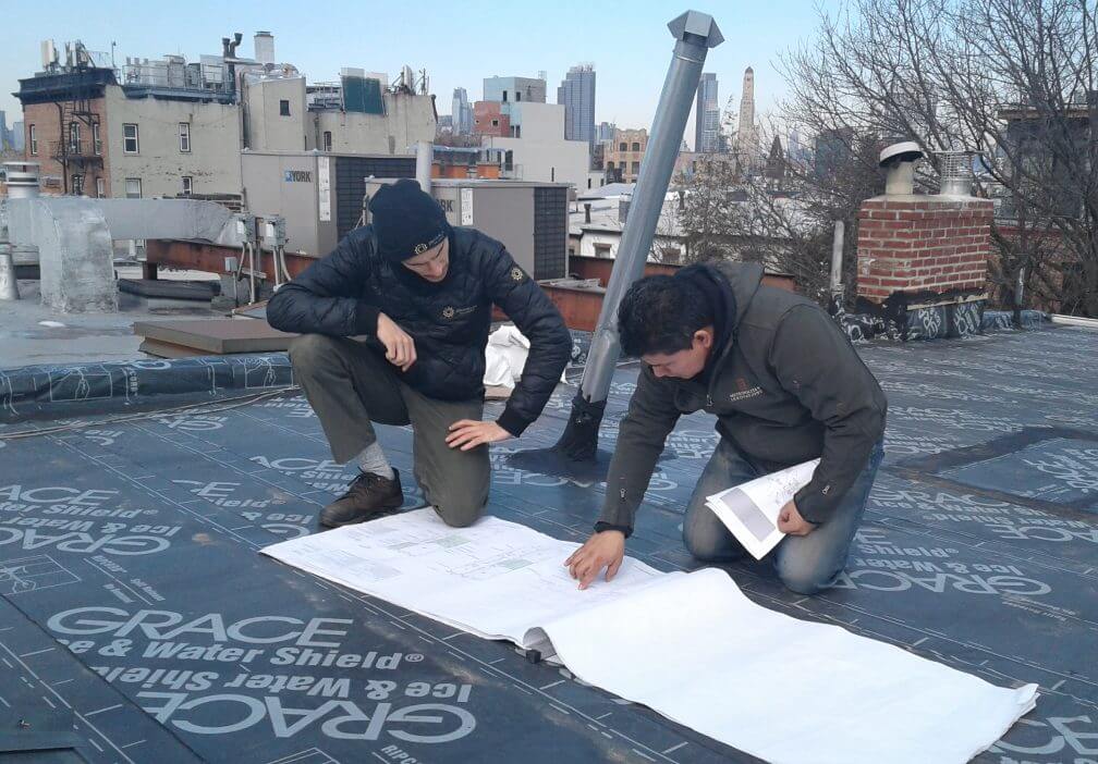 Brooklyn SolarWorks team looking at plans on a roof