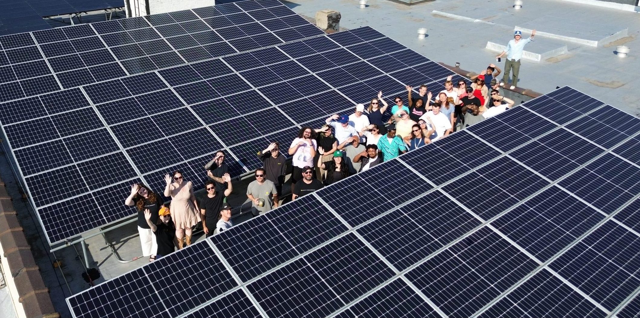 Team photo of the Brooklyn solarworks crew in gowanus brooklyn surrounded by solar panels.