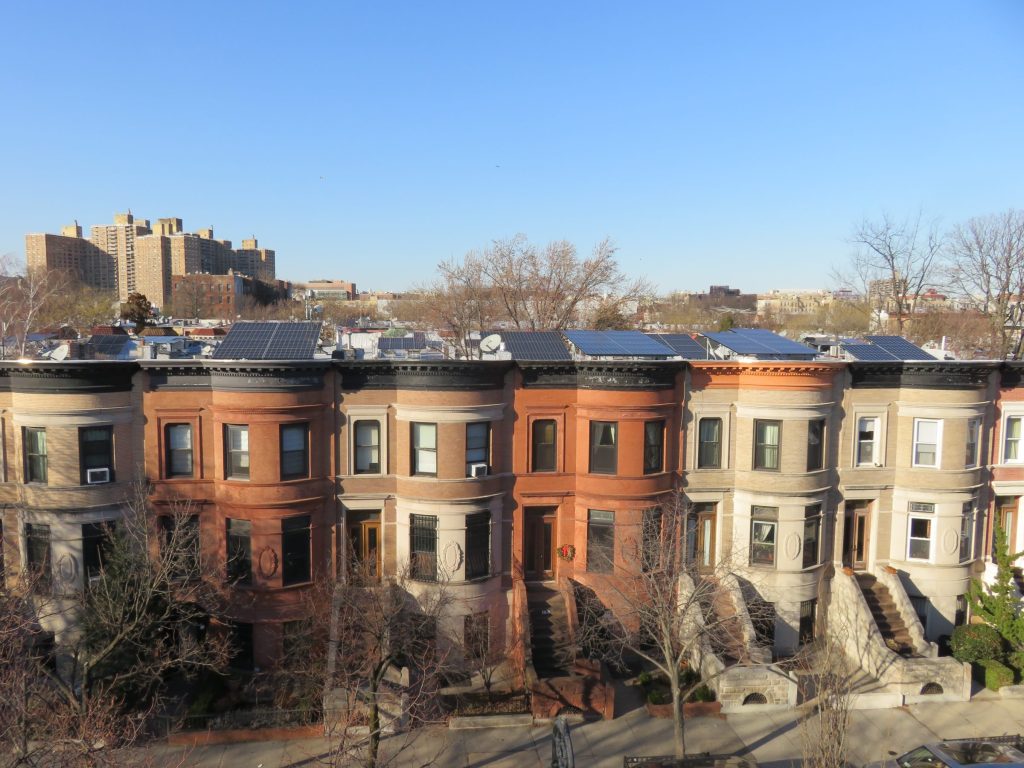 A block of landmarked brownstone homes in Prospect Lefferts Garden (PLG) with solar tilt rack systems installed on the roof by Brooklyn SolarWorks.