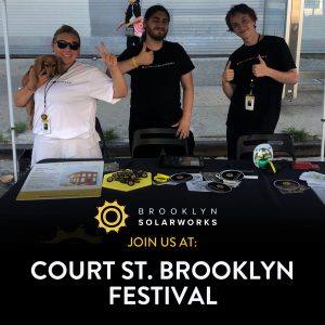 Three Brooklyn SolarWorks canvassers at a booth at a street fair in New York City.