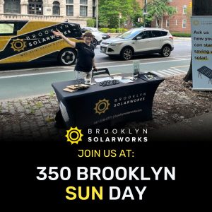 Brooklyn Solarworks team member standing behind booth waving to camera