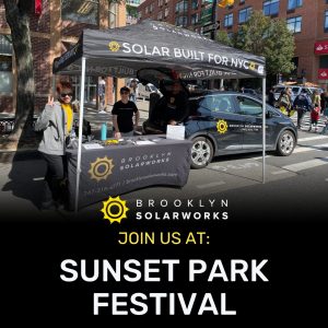 Brooklyn Solarworks team member standing behind booth waving to camera
